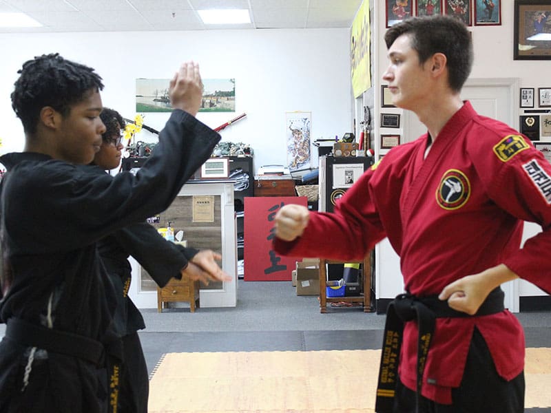 Adult martial arts instructor coaching student with focus mitts during fitness training in Snellville gym