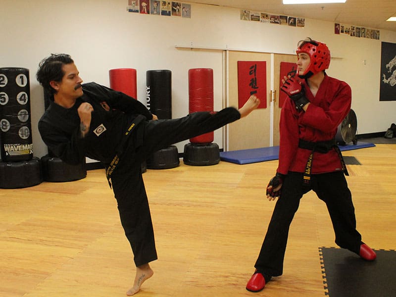 Adult martial arts students practicing self-defense techniques in Snellville dojo