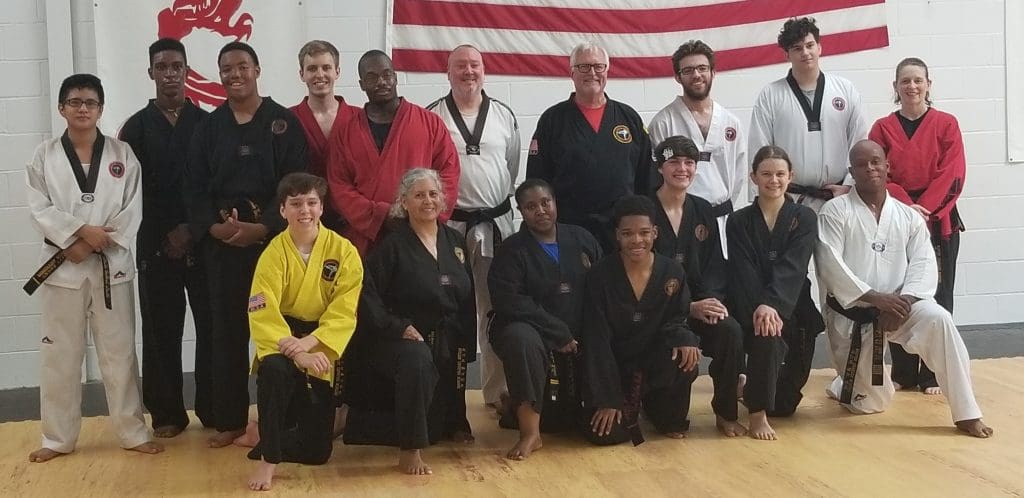 Adult martial arts students relaxing and socializing after training in Snellville gym