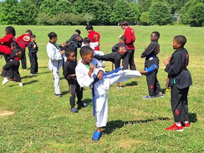 Happy kids in Snellville learning martial arts, improving balance, coordination, and having fun while building life skills.